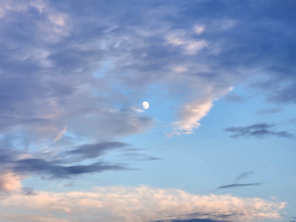 A picture of the waxing moon among dynamic clouds.