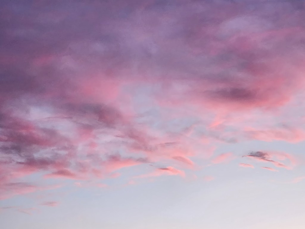 A dusk sky with pink and purple clouds.